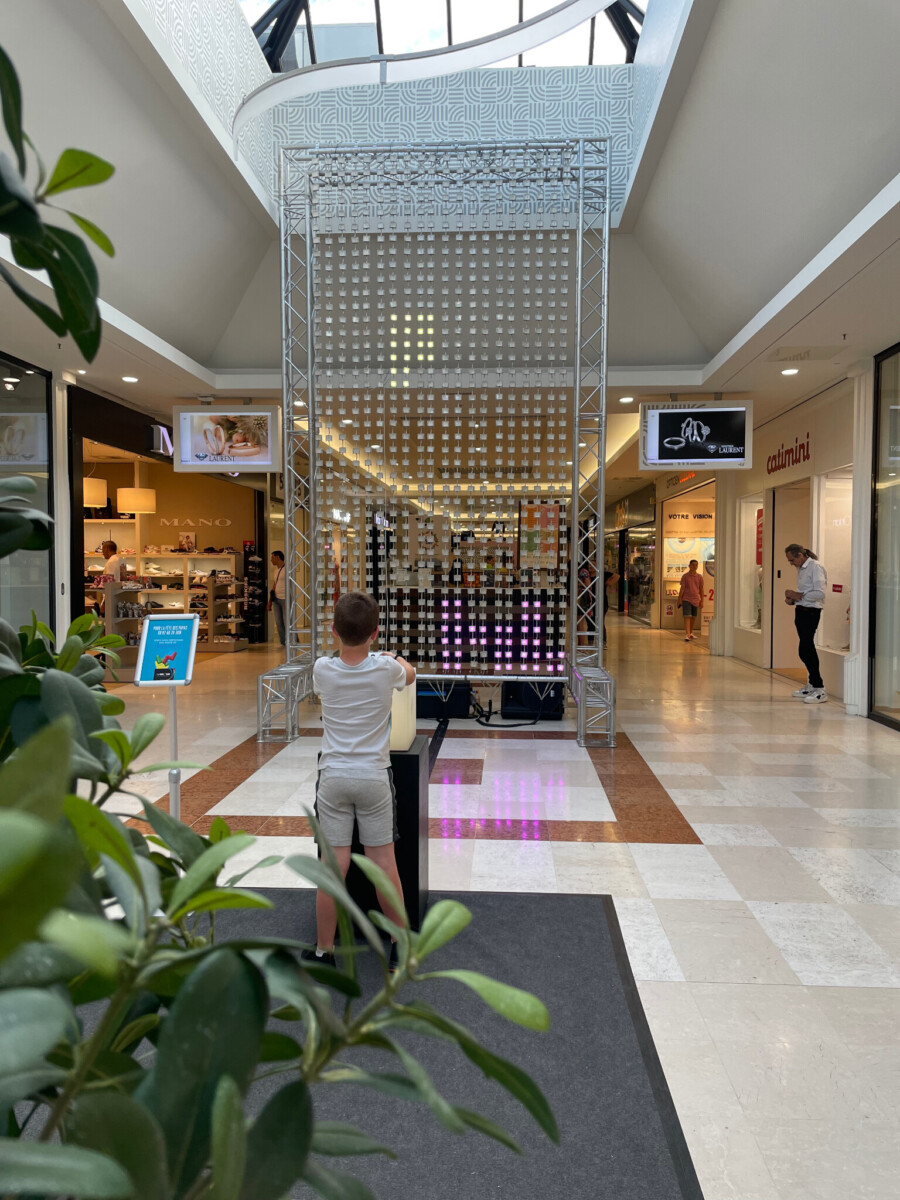 Personne jouant au jeu MEGA Light Tetris géant au centre commerciale Ville2 Belgique.